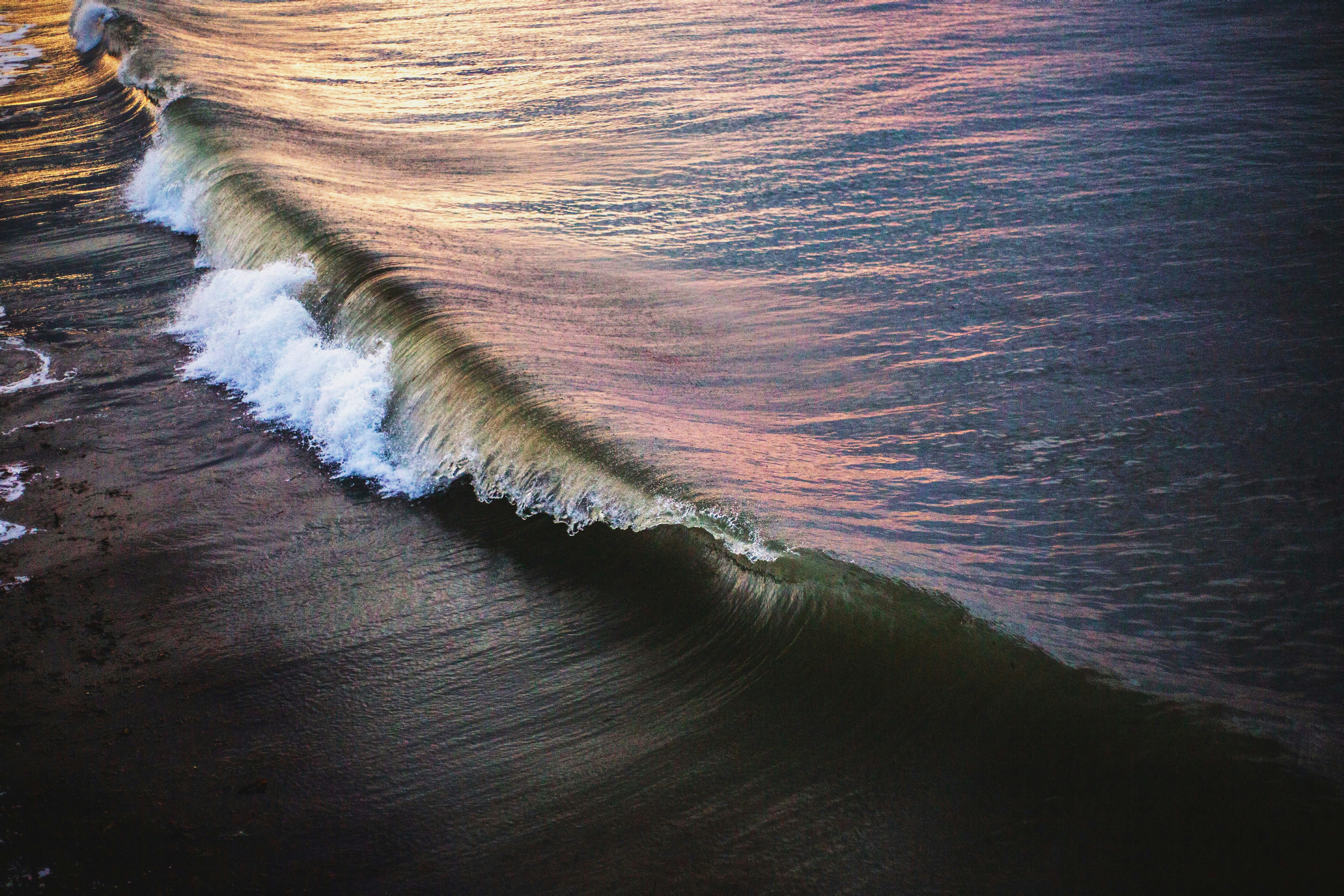 ocean waves crashing on shore during daytime